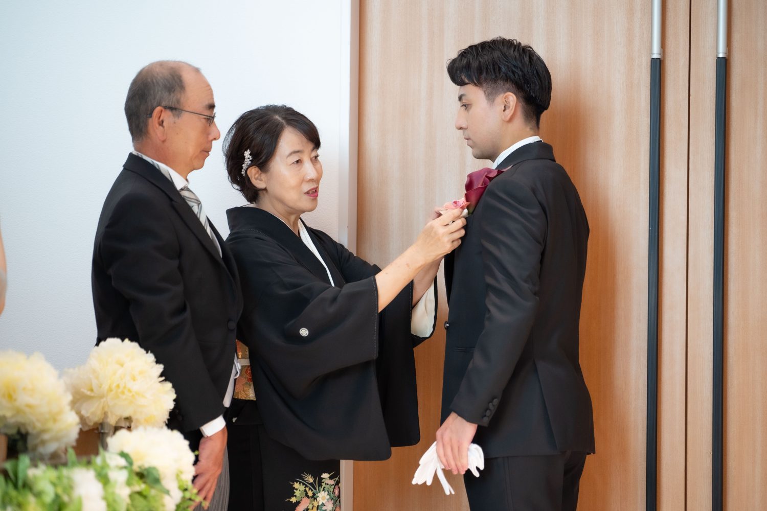 新郎様、最後の身支度をお父様・お母様に手伝ってもらいバージンロードを進んで行きます